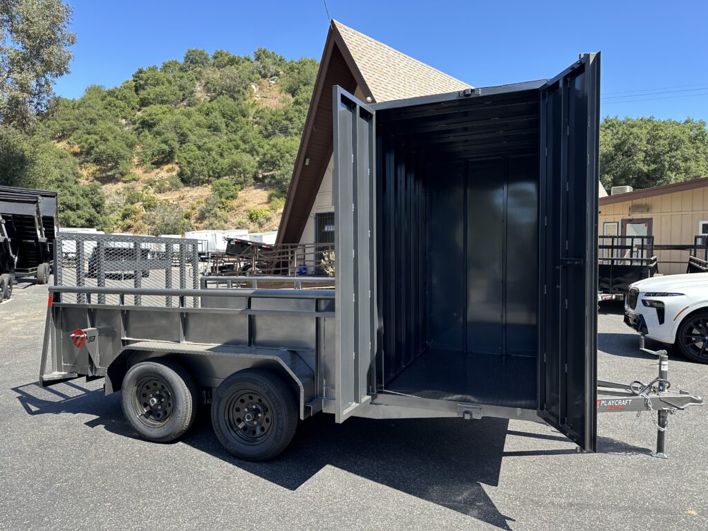 Curbside of custom landscape trailer with 4' x 83" x 6.5' tall enclosed box on the front and 10' of length in the open bed of the trailer. Image showcases inside the enclosed box with the double doors open.